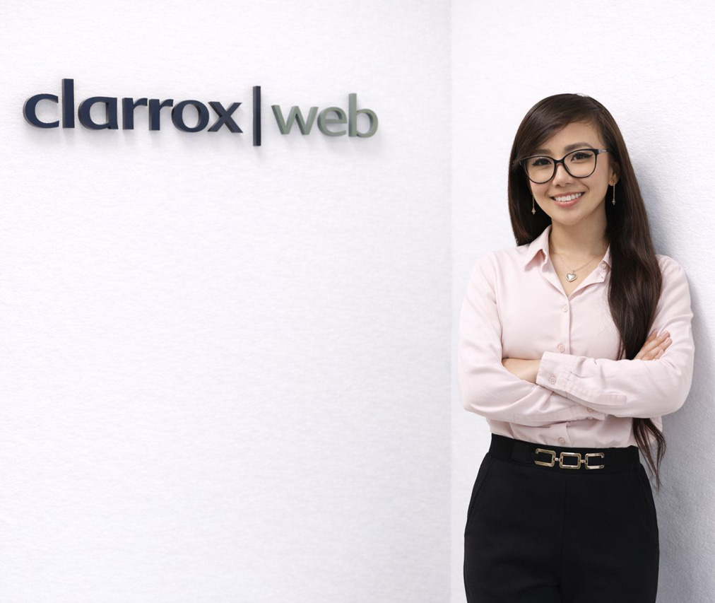 Em Dangla in front of the ClarroxWeb sign